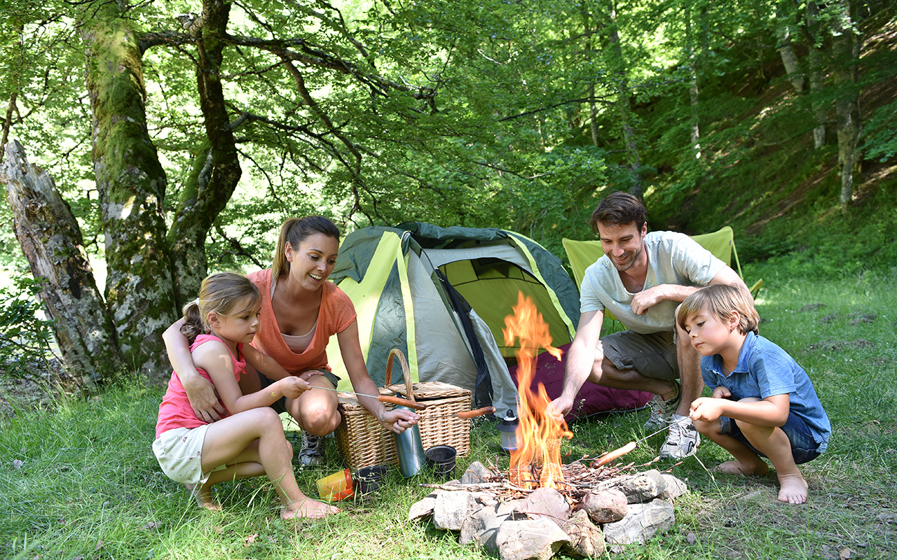 familycampingandcookingsausagesincampfire3